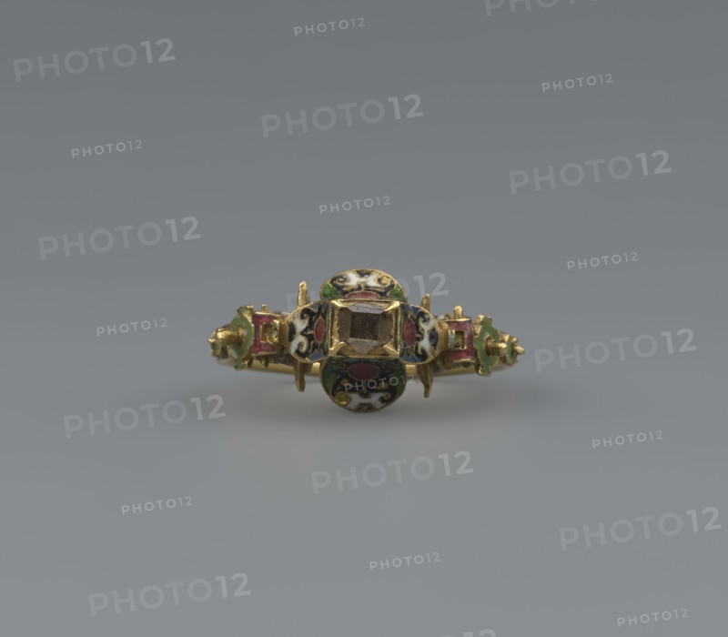 Women's ring, 19th century, Poland, jewelry, height 2.4 cm, width 2.1 cm, A small ornamental ring is centered against a smooth gray background, the ring made of gold with a central faceted stone held in a square bezel and flanked by decorative round and rectangular enamelled panels; the enamel shows colors including green, red, black, white, and blue, and the metal has a yellow-gold tone.