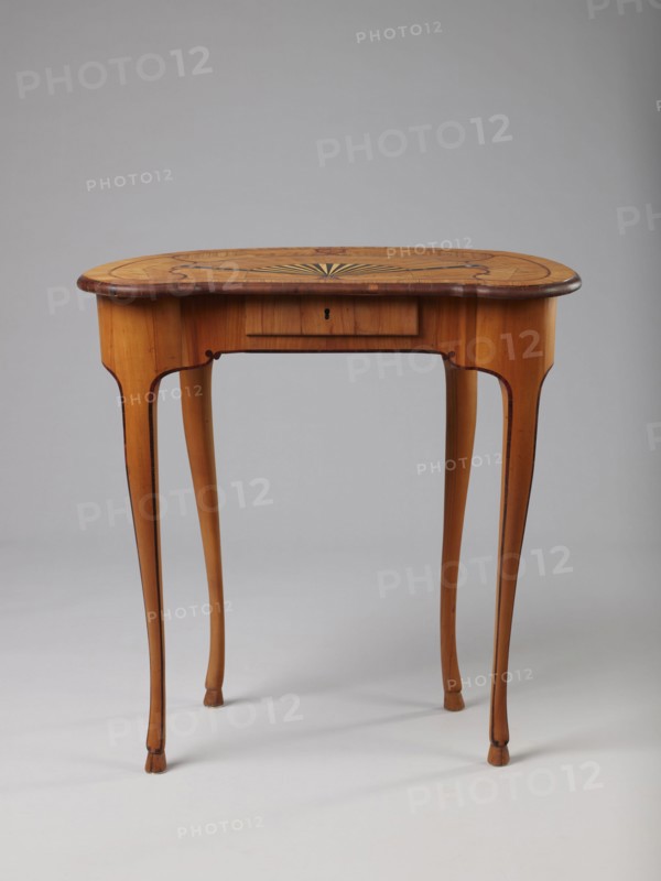 Table, Auxiliary table, ca. 1730–1750, Saxony . Height 72.5 cm, width 71.5 cm, depth 46.2 cm. Supported by four slender, slightly curved S-shaped legs framed and bound with a rosewood ribbon; feet in the form of hooves, stained black. Front frame concave with a small central drawer. Tabletop decorated centrally with a fan enclosed by four fields separated by an irregular rounded ribbon and a narrow crosswise frame; fan setting inlaid with mother-of-pearl rosettes and bound with tin veining, lower part of the fan showing alternating light and dark areas. Tabletop edge veneered with yew solid wood. Mortise lock, single-bolt with brass plate. Ornament: fans, ribbon-and-pincer, hooves animal legs., A wooden table with a rounded rectangular top showing a decorative sunburst pattern inlaid at the center and darker inlaid accents along the edge, supported by slender cabriole legs that taper to small pad feet; the table displays warm tones of honey brown and amber with darker brown outlining a...