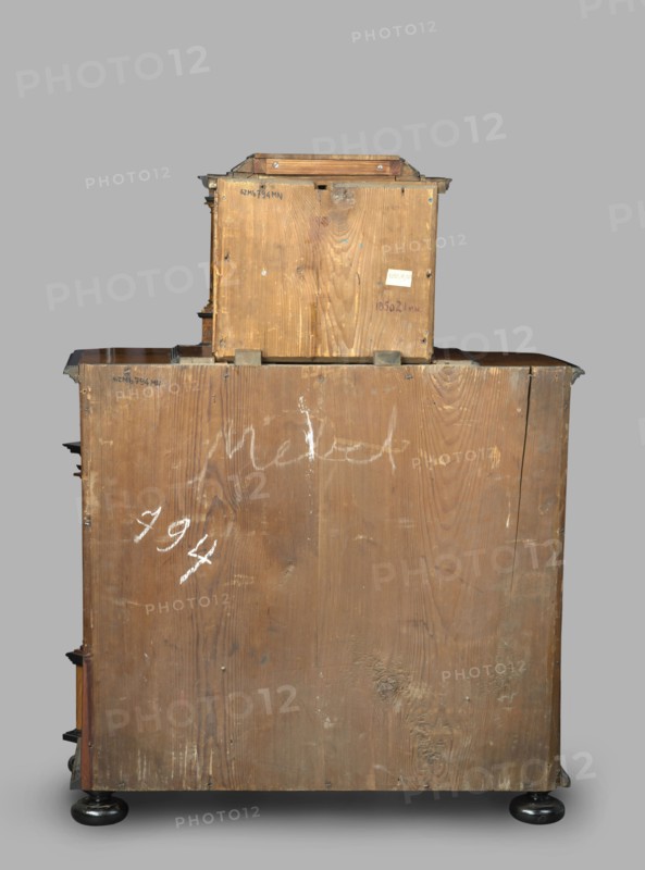 Cabinet, baroque style, columns, birds, early 18th century, Southern Germany, possibly Augsburg, piece of furniture storage piece, height 114 cm, width 92 cm, depth 41 cm, A large wooden box-like structure with a smaller wooden box stacked on top, both showing visible wood grain and a worn, rough surface in brown tones; a few white scuff marks and smudges appear on the wood, including some chalky white marks; metal corner brackets and small metal fasteners are visible at edges, showing a darker metallic color; the assembly rests on round black feet with a glossy finish, and the background is a flat neutral gray.