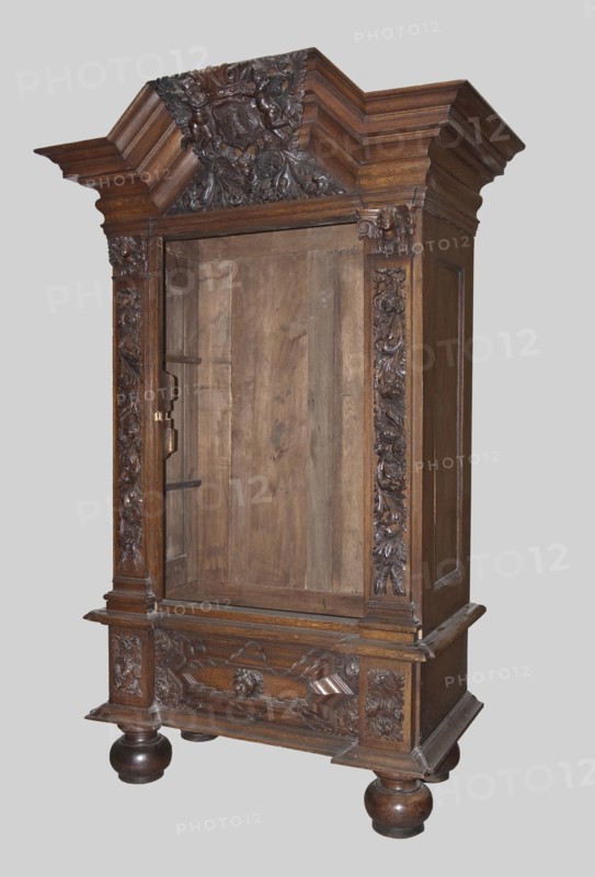 Wardrobe, provenance, putti; baroque style; coats of arms; plant decoration; lion masks; personifications of the seasons: Spring, Summer, Autumn, Winter; 1710–1730; Gdansk, Royal Prussia; piece of furniture storage; height 200 cm, width 124 cm, depth 62 cm, The image shows a large carved wooden cabinet standing against a plain light gray background. The cabinet is a dark brown wood with a rich grain and features ornate carved details along the top, sides, and lower front, including floral and scroll motifs and a central carved crest at the cornice. The interior of the cabinet is visible and shows rawer, lighter brown wood panels. The cabinet rests on rounded bun feet that are a darker brown and glossy, and it has decorative molding and raised panels on its sides and base. Several carved vertical panels flank the cabinet opening, and the top has layered cornice moldings in matching dark brown wood. The overall visible colors are shades of brown and the neutral light gray of the backgrou...