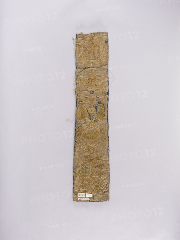Chasuble pillar, embroidery, coats of arms, liturgical vestments, Sreniawa coat of arms, Slepowron coat of arms, plant ornaments, church paraments, sacred art, churches and chapels furnishings. Chasuble column embroidered on dark blue velvet over an underlying thick linen canvas. At the top, in a radial medallion, the inscription IHS; below, a vase with stylized flowers; at the bottom, a four-field shield with the coats of arms: Slepowron, unrecognized, Brodzicz, Szreniawa. Above the shield the letters Z and K, below the shield E and V …Koscielecki Episcopus Vilnensis, see. at Niesiecki, J. Ch., perhaps Varmiensis?, MJ. Embroidery: laid metal threads on bases of various heights made of linen threads. Metal threads in gold and silver: cut plate, plate braided on a silk thread, bullion, drawn wire, attached with linen and silk yarn. Embroidery with silk yarn in flat, split, and banner stitch. Attributed to 17th century, Poland. Materials: fabrics. Dimensions: length 90.5 cm, width 18 cm....