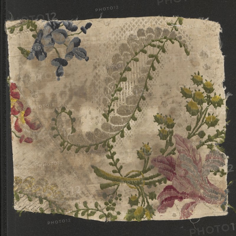 Fragment of fabric, fabrics, fragments of silk patterned fabric, 18th-century silk fabric. Decoration: spiky, corrugated, curling leaves in gold-green-white with fanciful forms; small flowers snapdragons and larger flowers between a lily and an iris. Louis XV style. Colors: white grosgrain background with a loose weft thread complementing colorful brocade motifs; brocade: white, sky blue, ink, light grass green, celadon yellow, pale pink, pink burgundy, rusty red, orange, lemon. 18th century, France. Height 18.6 cm, width 20 cm., A square piece of worn fabric with a beige background showing a floral and vine pattern in a few colors including green, yellow, blue, red, pink, and gray. The fabric has a large curved vine with small green leaves and a scalloped grayish decorative band, clusters of small yellow flower buds on green stems, a cluster of blue petal shapes near the top edge, and a large pink and red feathery flower near the lower right. The surface shows mottled discoloration an...