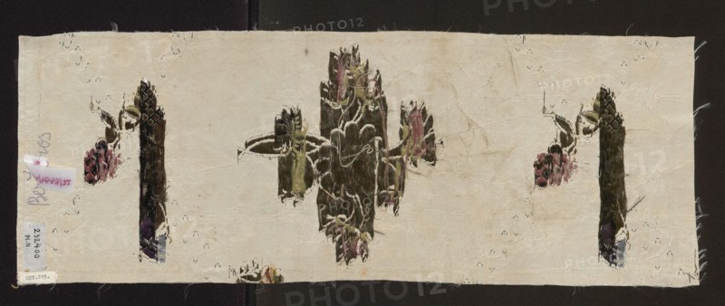 Fragment of fabric, mid-18th century, England, silk, gros de Tours?; woven: background rep weave, pattern broché with liseré and broaching threads persienne. Pattern: twigs and bouquets in a rhomboidal network of small silver motifs; branches with grape clusters, rose buds and single flowers. Colors: white background; padding threads in light and dark pink, green, blue; delicate floral and fanciful motifs on white. Dimensions: length 38 x ?, height 21 cm, width 57 cm., A rectangular piece of light beige fabric with frayed edges lies against a dark background, showing a central vertical motif of elongated, brushlike shapes in dark brown and olive green with touches of pink and pale yellow, flanked by smaller similar motifs toward the sides; a few scattered stitched outlines in white and dark threads trace parts of the motifs, and there are a few small areas of pink, purple, and pale blue near the lower portions of some vertical shapes, along with faint creases and slight discoloration a...