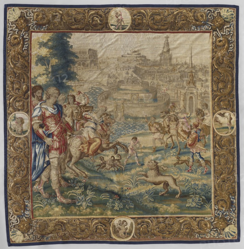 Figural tapestry, maker, design attributed to Maarten van Heemskerck 1498–1574 as draughtsman; unknown provenance. Subject: in the center foreground a woman on horseback surrounded by courtiers hunts a lion; background shows city buildings with a circular structure Tower of Babel. Decorative elements: flowers, floral ornaments, borders with an acanthus twig motif and medallions containing allegorical representations. Iconography: Semiramis legend, queens, riders, hunting, legendary representations, lion. Materials/technique: woven tapestry decorative fabric for interior furnishings/decorations. Colors: sand, brown, green, red. Date: 1680s. Place of origin: Netherlands. Dimensions: height 308 cm, width 300 cm., A woven tapestry panel depicts a large outdoor scene with figures, animals, and an architectural cityscape in the background, all surrounded by an ornate decorative border. In the central scene a group of people in historical clothing stand and ride horses across a grassy field w...