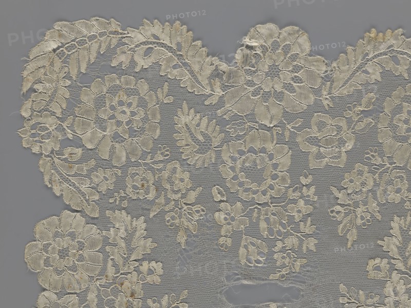 Shawl, shawls, clothing accessories, women's clothing, fashion, lace with serrated edges, design of twigs with two flowers in the bends and curling flower twigs in the middle part, 19th century, Europe, length 48 cm, width 260 cm, purchase provenance., A delicate lace fabric laid flat against a gray background, showing an intricate floral and leaf pattern with openwork sections and scalloped edges; the lace appears in shades of off-white, cream, and light beige with subtle darker beige discolorations in a few areas, and the background is a uniform gray.