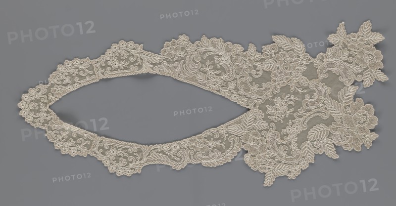 Collar, origin unknown, floral ornaments, clothing accessory for women's fashion, embroidery, connected at the bottom by a wide, irregular inset, 2nd half of the 19th century, Europe, width 19 cm, length 50 cm, A delicate piece of lace with intricate floral and leafy embroidery lies flat against a smooth background, showing an elongated oval opening flanked by ornate scalloped edges and a larger, more elaborate cluster of embroidered flowers and leaves at one end; the lace is a light beige or cream color with detailed looping and swirling threadwork, and the background is a muted medium gray.