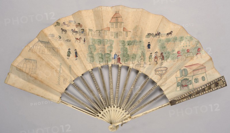 Cabriolet fan. A fan with a frame of carved and foil-inlaid ivory. The leaf is decorated with an amateur drawing depicting a country estate with documentary precision. The cover feathers are decorated with fine Rococo ornamentation, inlaid with silver and colored foil. In the center of the drawing, a couple strolls along a garden path leading to the palace; in the background are farm buildings, a stable, a coach house, and horse-drawn vehicles, as well as several figures engaged in farm chores and a group of soldiers. In the garden: military tents, a henhouse, a swing, a sundial, and a card table. Architecture and clothing of figures from the 3rd quarter of the 18th century, 1780s. Place of origin: Germany? Europe. Subject categories: genre scenes, carriages, horses, gardens, fans; clothing accessories. Height: 28 cm., A folding hand fan with pale beige leaf showing a painted outdoor scene in muted colors, including a pale red-roofed building at center, a pale green and red smaller bui...
