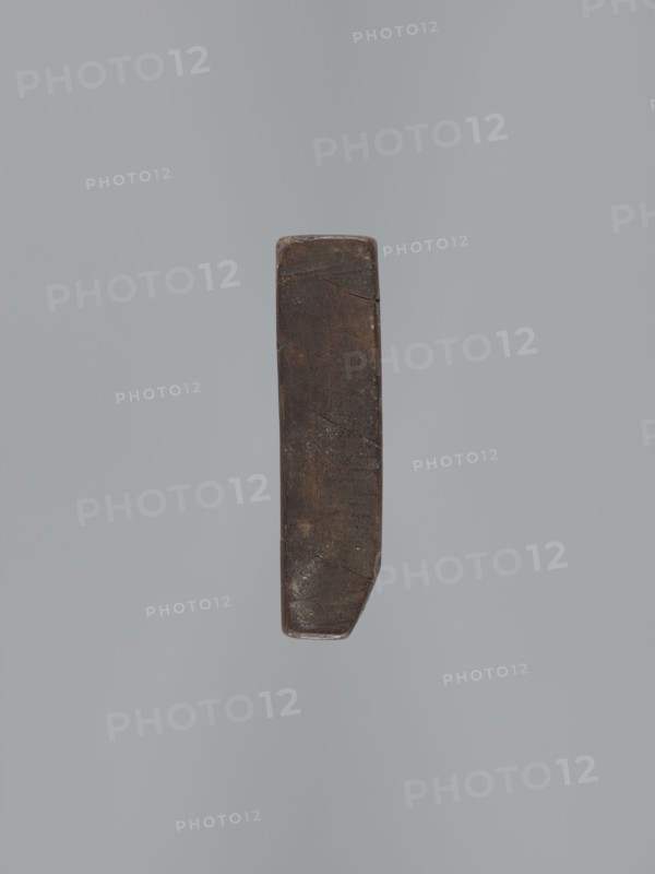 Double-sided gingerbread mould. Obverse: rectangular floral and geometric ornament — a rectangular decorative motif containing a rosette and stylised plants. Reverse: figure of the Archangel Michael in a long patterned robe decorated with a plant twig motif, holding scales in his right hand and a sword in his left; at the feet of the figure a geometric-plant ornament. Date engraved on the edge: 1806, with the letter S against the background of an anchor mark of the woodcarver or gingerbread maker — owner of the mould., woodcarver or gingerbread maker. Gingerbread, decorative art, folk art; figurative religious iconography Archangel Michael, Christianity; folk-style decorations, floral ornaments. Silesia Province of Silesia, 1742–1918. Double-sided, rectangular mould; bas-relief. Height 11.6 cm, width 30.5 cm, depth 3 cm., A single narrow vertical object with a worn, rectangular shape and rounded edges sits against a plain gray background; the object appears dark brown with lighter brow...