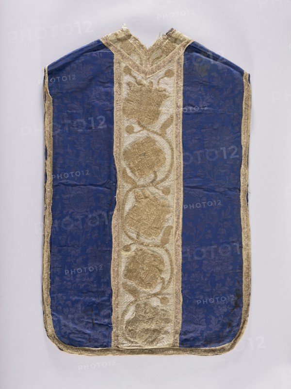 Chasuble, 17th century, Poland. Liturgical vestment. The sides are made of semi-silk navy blue damask 19th-century fabric with a motif of twisting floral sprigs. Columns have a tendril motif with schematic tulips and roses, embroidered with metal thread: silver in the background, gold in the ornamental sections. Edges and internal divisions trimmed with metal galloon. Cotton lining. Embroidery: gold metal thread on thick linen canvas backing. Background, leaves, and buds executed in flat laid embroidery; flower cups and stems in raised laid embroidery on a backing of linen threads. Gold threads consist of gold-colored metal plate ornamental parts and silver-colored metal plate background woven on a linen base; threads attached with linen yarn. Dimensions: length 114 cm, width 66 cm back., A vestment-like textile with a central vertical panel of metallic gold fabric featuring textured circular floral motifs bordered by narrower gold trim, flanked on both sides by deep blue panels patter...