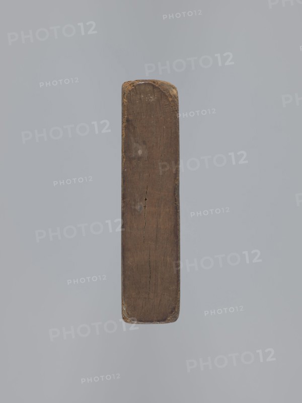 Double-sided gingerbread mould. Obverse: vase with flowers in a frame; reverse: rectangle with a plant ornament. Double-sided mould of a rectangular shape; on one side an oval frame containing a decorative vase with flowers surrounded by a wreath of leaves; other side: rectangular recess with a rectangular frame formed by a plant ornament, featuring a rose motif and the initials E and G. 18th–19th century. Province of Silesia 1742–1918. Mould; height 16.5 cm, width 11.5 cm, depth 2.7 cm., A vertical rectangular wooden beam with rounded ends suspended against a plain light gray background, showing a weathered brown surface with visible grain, cracks, and worn edges, and small areas of darker and lighter brown discoloration.