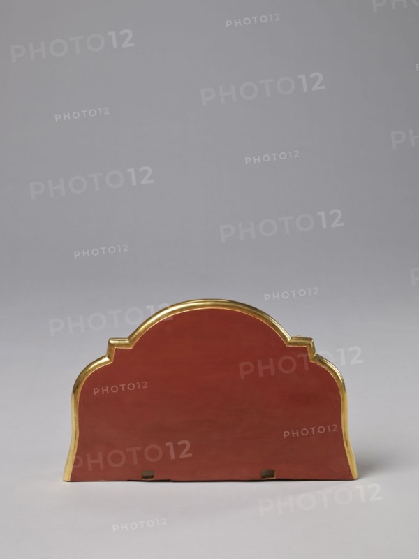 Hanging console, acanthus ornament, floral ornament, rococo style, ca. mid-18th century, Central Europe, piece of furniture, height 37.3 cm, width 41.5 cm, depth 26 cm, An object with a rounded, scalloped top and straight base sits centered against a plain light gray background; the main visible surface of the object is a deep red color with a shiny gold trim outlining its curved edges, and a few small darker rectangular cutouts are visible along the bottom edge.