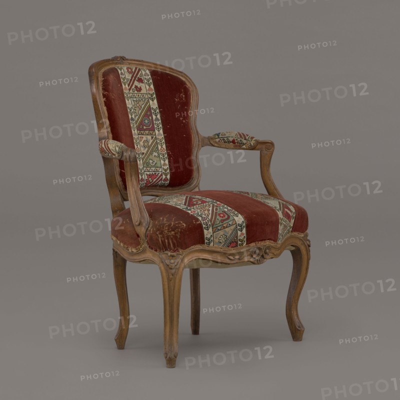 Armchair, rococo, flowers, geometric ornament, ca. 1760, France; piece of furniture seating piece; height 85.5 cm, width 62 cm, depth 60 cm., A wooden armchair with carved curved legs and frame upholstered in a worn red velvet fabric accented by patterned vertical strips in cream, green, red, and black; the armrests have small padded sections covered in the same patterned fabric, and the chair shows scuffs and worn areas on the seat and back; the wood has a light brown finish and the background is a smooth gray.