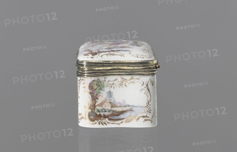 Snuffbox tin, Koenigliche Porzellain Fabrique, Meissen 1710–1763. Tall rectangular snuffbox with rounded corners, flatly arched lid bound in metal gilt silver? on hinges. Around the edges of the side walls, lid, and bottom are gilded rocaille frames for colorful miniatures with animal fairy tales: 1 a squirrel and a pug in a bonnet and cape, smoking pipes and drinking coffee, with a landscape and architecture in the background; 2 a dog as a hunter with a pipe and two hares on a leash, landscape background; 3 drunken animals feasting at a table with a pulled tablecloth: a goose, a wild boar, and a fox, with landscape background; 4 a parrot on a pole beside a cage, with landscape background. In the reserves on the side walls are miniature waterside landscapes. Inside the lid is a colorful miniature portrait of a young lady in a cape, half-length, against beige drapery partially obscuring a column. The miniature is painted in pastel colors in a pointillist style, dated to the third quarte...