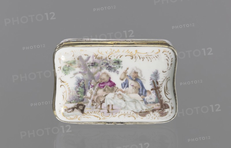 Snuffbox tin, Koenigliche Porzellain Fabrique, Meissen 1710–1763. Tall rectangular snuffbox with rounded corners and a flatly arched lid bound in metal gilt silver?, hinged. Around the edges of the side walls, lid, and bottom are gilded rocaille frames for colorful miniatures with animal fairy tales: 1 a squirrel and a pug in a bonnet and cape, smoking pipes and drinking coffee, with a landscape and architecture in the background; 2 a dog as a hunter, with a pipe and two hares on a leash, with a landscape background; 3 drunken animals feasting at a table with a pulled tablecloth: a goose, a wild boar, and a fox, with a landscape background; 4 a parrot on a pole beside a cage, with a landscape background. In the reserves on the side walls are miniature waterside landscapes. Inside the lid is a colorful miniature portrait: a young lady in a cape, half-length, against beige drapery partially obscuring a column; painted in pastel colors in a pointillist style, 3rd quarter of the 18th centu...