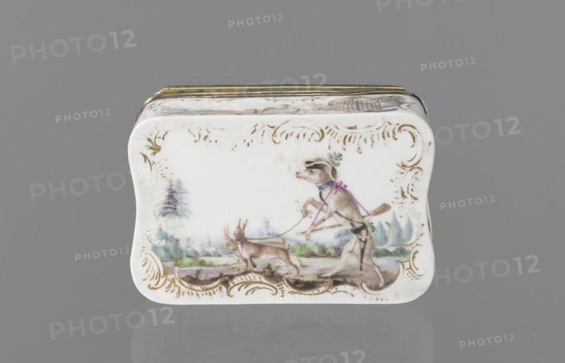 Snuffbox tin, Koenigliche Porzellain Fabrique, Meissen 1710–1763. Tall rectangular snuffbox with rounded corners, flatly arched lid bound in metal gilt silver? on hinges. Around the edges of the side walls, lid, and bottom are gilded rocaille frames for colorful miniatures with animal fairy tales: 1 a squirrel and a pug in a bonnet and cape, smoking pipes and drinking coffee, landscape with architecture in the background; 2 a dog as a hunter, with a pipe and two hares on a leash, landscape in the background; 3 drunken animals feasting at a table with a pulled tablecloth: a goose, a wild boar, and a fox, with a landscape in the background; 4 a parrot on a pole, next to it a cage, with a landscape in the background. In the reserves on the side walls are miniature landscapes by the water. Inside the lid is a colorful miniature portrait: a young lady in a cape, half-length, against beige drapery partially obscuring a column. The miniature is painted in pastel colors in a pointillist style,...