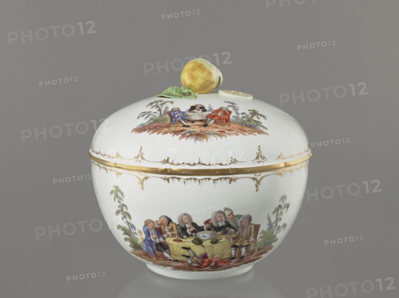 Punch Vase with Lid, Königliche Porzellan-Manufaktur KPM, Berlin; 1763–1918, porcelain, reliefs, polychrome miniatures. Hemispherical bowl with a bottom rim and an arched circular lid topped by a modeled half peeled lemon with stem, leaf, two slices and rolled peel. Rim of vase and lid with gilded relief rocaille decoration. Two color miniatures on the lid park scenes: 1 three men in 18th-century costume seated at a table with a vase and glasses; 2 three men at a table with a vase, one standing. Two color miniatures on the bowl park settings: 1 six people seated at a round table with glasses and pipes, one reclining before the table; 2 seven people seated at a table, singing, smoking pipes and conversing. 4th quarter of the 18th century, Berlin, Germany. Vase; height 27.5 cm, width 28 cm., A rounded white porcelain jar with a domed lid sits against a gray background; the lid is topped with a sculpted yellow fruit and a green leaf. The jar and lid feature painted scenes of people in per...