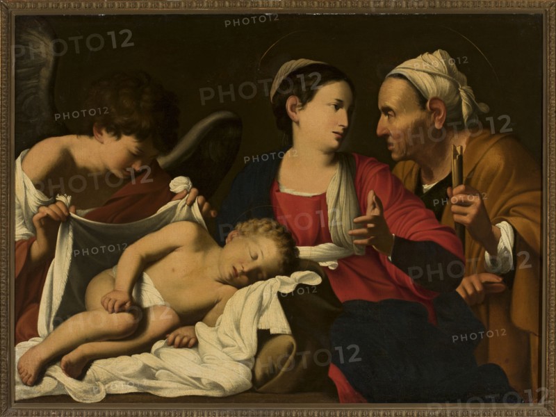 Virgin Mary with Child, St. Anne and an Angel, Saracens, Carlo ca. 1579–1620 painter workshop replica, religious scene, religious painting, Italian painting, Jesus Christ, angels, Anne saint, Mary mother of Jesus Christ, 1st quarter of the 17th century, oil painting, height 92.5 cm, width 127 cm, A framed painting showing a group of figures gathered closely around a sleeping child lying on white cloth; the child has light skin and curly light brown hair and appears unclothed except for a white cloth covering part of the body. To the left, a young figure with dark curly hair and pale skin holds a white cloth and leans toward the child, wearing a garment with red and white visible and a dark wing behind them. At center, a woman with pale skin and dark hair pulled back wears a red outer garment with a dark blue inner garment and a pale head covering draped over one shoulder, her hand raised with fingers extended toward the older figure on the right. On the right, an older person with pale...