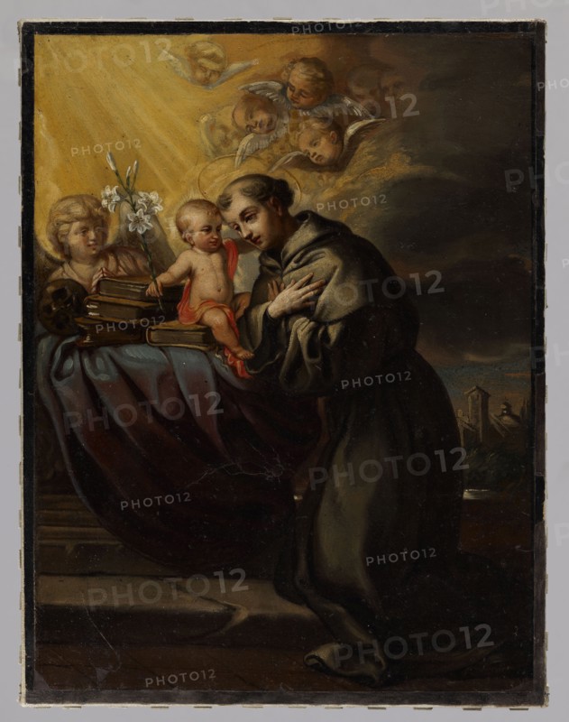 Saint Anthony of Padua; Boleslaw Rusiecki 1824–1913, painter; 2nd half of the 19th century; painting; height 35 cm, width 27 cm; repossession Vilnius., A painted scene showing a man in a dark robe kneeling with hands crossed over his chest, facing a small child seated on a draped surface; the child wears a red cloth and reaches toward the man. Nearby is a young figure with pale skin and light hair holding white flowers and positioned beside a stack of books. Several cherubic faces with wings appear in the upper area, surrounded by golden light rays that contrast with darker brown and gray clouds. The foreground drapery shows deep reds and blues, and the lower area includes dark browns and blacks suggesting a floor. Hints of green and muted browns appear in a distant landscape at the right edge. Overall colors visible include gold, yellow, red, blue, brown, gray, black, white, and green.