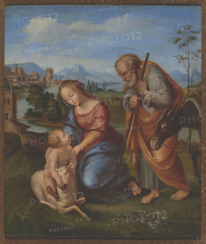 Holy Family with a Lamb, Penni, Giovanni Francesco ca. 1496–ca. 1528, painter; Raphael 1483–1520, painter copy after; religious painting depicting the Holy Family Mary, Joseph, and the infant Jesus with a lamb; scenes against a landscape background; Italian painting and Italian landscape style; after 1507; painting; dimensions: height 43.5 cm, width 38 cm; with frame: height 68 cm, width 59.5 cm, thickness 6.5 cm., A painted scene shows a woman in a red top and blue skirt kneeling beside a small naked child who is sitting on a light-colored sheep; a bearded man wearing muted green and rust-colored garments stands nearby leaning on a staff and a dark donkey is close to him; the background contains a landscape with green trees, a river or body of water, distant bluish mountains, and a pale blue sky with a few white clouds, and the ground in the foreground is grassy with small plants and flowers.