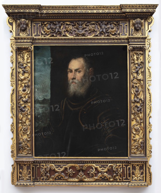 Portrait of a Venetian Admiral, Tintoretto, Jacopo 1519–1594, painter; Italian painting; portraits of men; landscapes; seascapes; Venetians; armor; Venetian painting; masterpiece; 2nd half of the 16th century, Venice; painting; height 81 cm, width 68 cm, A painted portrait of an older man with a gray beard and mustache wearing dark clothing with faint outlines of armor, set against a dark background with a narrow vertical strip of blue-green on one side, all contained within an ornate rectangular frame carved with floral scrollwork and small cherubic faces and finished in gold and dark brown tones.