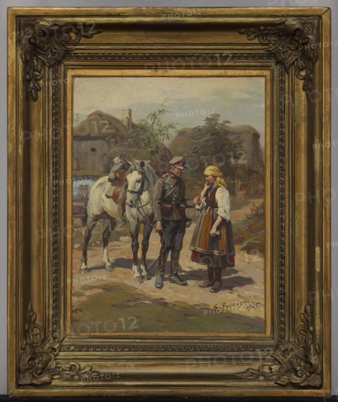 Soldier and a Peasant Girl, Stanislaw Bagienski 1876–1948, painter; 1925; oil painting; 45.5 × 35.5 cm, A framed painting shows a rural outdoor scene with a group of figures and a horse in front of thatched buildings and trees. The frame is ornate and golden with decorative corners and a multilayered inner border. Inside the frame, a white horse with a brown saddle stands beside a man in a dark uniform with a peaked cap, and a woman wearing a dress with an apron and a yellow headscarf; the man and woman face each other. The ground is earthy with tones of brown and green, and the background sky is pale blue with muted clouds. Visible colors include gold on the frame, white and brown on the horse, dark gray and green on the uniform, yellow on the headscarf, brown and red tones in the woman’s skirt, and green and brown in the foliage and thatch.