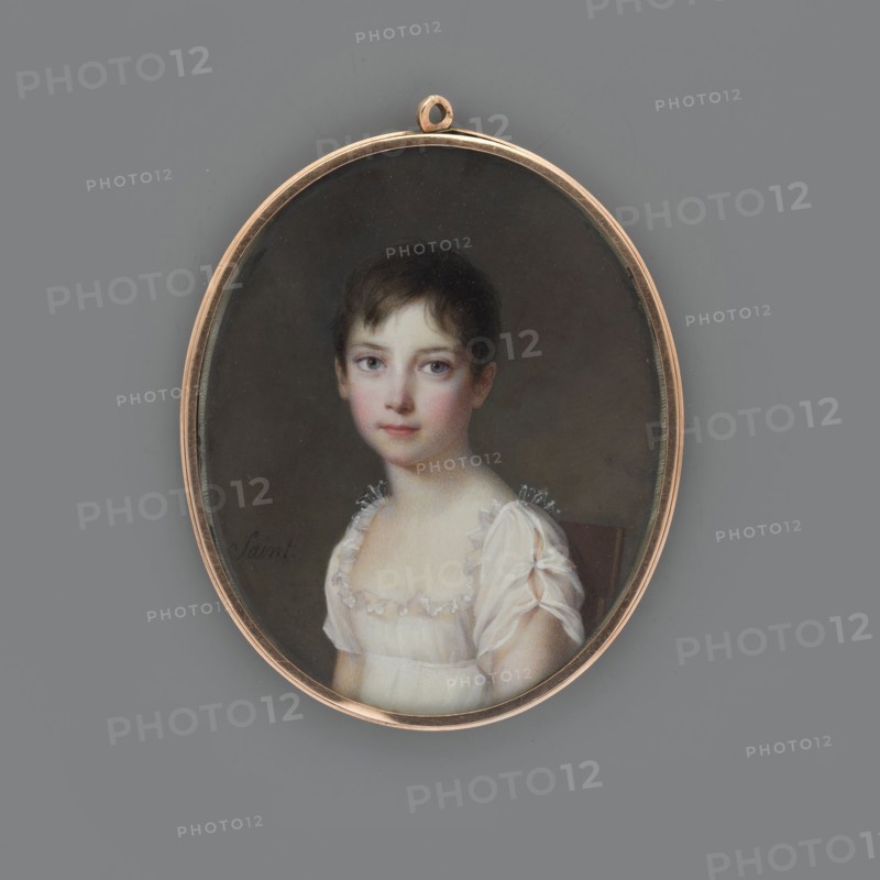 Anna Sapieha as a child, later Princess Adamowa Czartoryska, Saint, Daniel 1770–1847 author; Bust 3/4 left, head almost straight; short dark brown hair; white dress of thin fabric—low-cut with a transparent ruffle at the bodice, short slit sleeves; uniform grey-brown background; miniature, gilded bronze narrow oval rim, 1810, France; height 6.6 cm, width 5.3 cm., An oval pendant with a thin gold frame contains a painted portrait of a young person with short dark brown hair and pale skin, wearing a white, sheer dress with frilled shoulders; the sitter faces forward with a neutral expression and light-colored eyes, set against a dark, muted background, and the pendant rests on a flat gray surface.