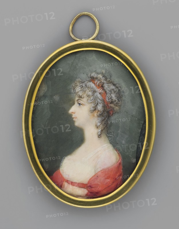 Portrait of a Woman in a White Empire Dress with a Red Shawl, Auvigny, Charles d' 1760–1830 painter. Women; female portrait; Polish miniature; profile portrait; hairstyles; costumes. Portrait of a woman, torso in left profile, dark powdered hair in loose curls on the forehead, temples and neck, tied with a red ribbon; profile with a sharp, aquiline nose and slightly receding chin; intensely blue eye. White Empire dress with lace at the bodice, red shawl and belt. Background: off-green. Binding: narrow gilt bronze frame. 1801. Poland. Miniature; height 6.4 cm, width 5.1 cm., An oval pendant with a gold-colored frame contains a painted profile of a woman with light skin and curly grayish-white hair tied with a red headband; she faces left and wears a low-necked garment showing bare shoulders with a red outer fabric and a pale inner fabric against a dark muted green background.