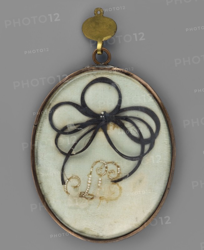 Portrait of a young girl in a white dress, painter unknown, shoulder-length portrait, Empire-style dress, young woman, slightly turned to the right, foreign miniature, 1825, miniature, height 7.2 cm, width 5.9 cm, An oval pendant with a metal frame and a brass loop at the top encloses a light pale green fabric background; on the fabric is an arrangement of dark black hair formed into looping ribbon-like shapes with a small cluster at the center, and below the hair is a decorative swirl made from a string of small light beads; the piece shows subtle stains and discoloration on the fabric and a few pale beige remnants near the bottom.