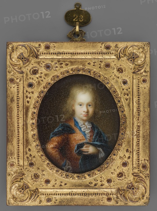 Louis VIII 1691–1768, Landgrave of Hesse-Darmstadt as a child. Painter: Arnold van Boonen 1669–1729; later author: Wilhelm Horst 1809–1852. Subject: a child visible to the hips, standing with hand on hip, turned 3/4 to the right, head almost straight; light blond hair, blue eyes. Costume: white ruffle at the neck, white lace at the sleeves, brown justaucorps embroidered with silver, sky-blue collar and cuffs, richly draped navy blue coat on the shoulders. Background: olive-brown. Frame: richly ornamented stucco, gilded wood. Medium/format: miniature; height 6.3 cm, width 5.2 cm. Date: circa 1850–1855. Comparative reference noted., A rectangular ornate frame in gold surrounds an oval portrait of a young person with pale skin and light blond hair; the frame has detailed raised patterns and decorative motifs with darker brownish accents and several small round embellishments. The portrait shows the figure wearing a reddish-brown garment and a deep blue draped fabric, with a white lace-lik...