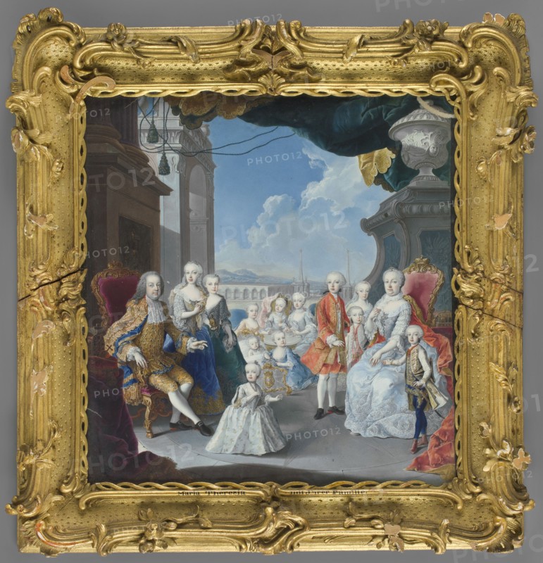 Empress Maria Theresa of Habsburg 1717–1780 and Francis I of Lorraine 1708–1765 with children, by Antonio Bencini 1710–1765, group portrait of parents and sixteen children, imperial family, open-air setting terrace with a view of Schönbrunn?, miniature, 1750, Austria; 26.5 cm × 25.5 cm., A framed painted scene showing a group of people posed indoors near an open view to the outdoors; the ornate frame is gold with carved scrollwork and floral motifs and shows areas of wear where the gold tone is chipped. Inside the frame, several adults and children are arranged on a stone floor in front of architectural elements including arches, a large column, and a balustrade opening to a distant landscape under a blue sky with white clouds; a heavy dark teal drapery with gold trim hangs from above. The figures wear elaborately styled garments in colors including blue, white, red, gold, and cream; some sit on red-upholstered chairs with carved wooden frames while others stand or kneel, and a small c...