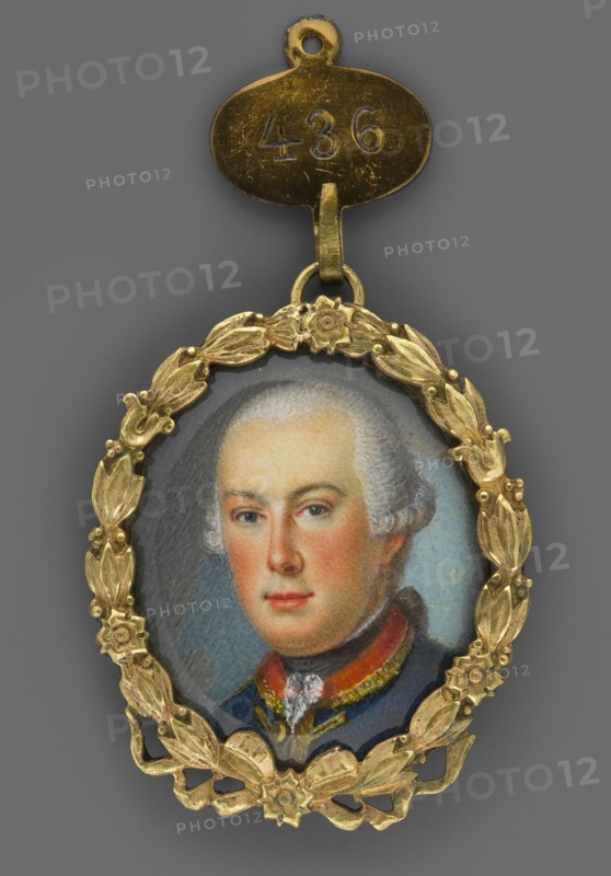 Ludwig IX, Landgrave of Hesse-Darmstadt 1719–1790, painted by Johann Ludwig Strecker 1721–1799, attributed to an unknown painter; portrait miniature, 1750, Germany. Subject: young man, 3/4 left, shoulder-length, blue eyes, grey wig with a ponytail katogan, hem of a white collar, black shawl, white frill; navy blue uniform with red collar and gold braiding — soldier/aristocracy costume. Medium: miniature, height 3.2 cm, width 2.6 cm. Background: turquoise gray and turquoise. Binding: gilded bronze with floral tendrils and rosettes., An oval miniature portrait pendant set in an ornate gold-colored laurel wreath frame with floral accents, suspended from a small gold-colored connector; the miniature shows a head-and-shoulders view of a person with pale skin and powdered light gray hair, rosy cheeks, and neutral expression, wearing a dark blue garment with a high collar and a red and gold-trimmed neckline; background behind the figure is a muted bluish-gray, and the overall visible colors i...