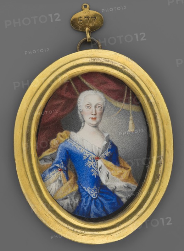 Maria Amelia Habsburg, Archduchess of Austria 1701–1756, unknown painter; knee-length portrait, en face almost, slightly to the right. Subject: older woman, white low wig, gray eyes, sapphire dress with white ruffle and white embroidery, corseted dress, ruby brooches at the neckline and sleeves, earrings, engagement rings, a yellow ermine cloak on the shoulders. Hairstyle: low wig. Background: gray, lightened near the face, magenta curtain with yellow fringes and a tassel. Format and materials: foreign miniature, gilt bronze binding with profiled rim. Date: 1830. Dimensions: height 7.5 cm, width 5.7 cm., An oval gold-colored frame surrounds a miniature portrait of a seated woman wearing a blue dress with ornate gold embroidery and a white ruffled neckline, a gold and white fur-lined cloak draped over her shoulders, pale skin and powdered white hair, a neutral expression, and light-colored eyes; behind her is a dark red drapery with gold trim and a gray background, and the frame is atta...