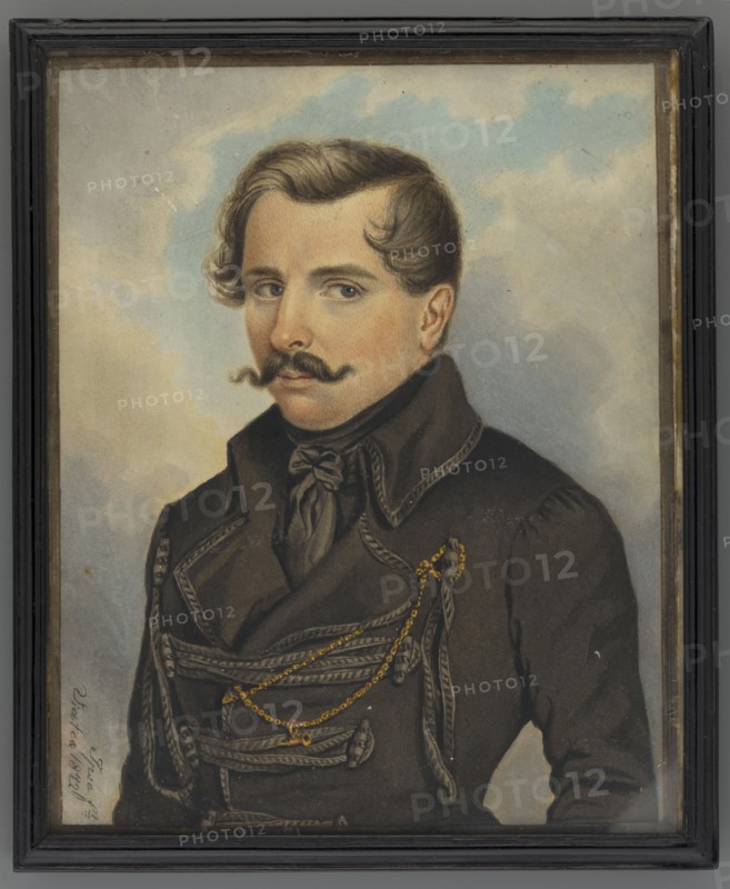 Self-portrait in a czamara by Roman Wilczynski 1807–1857. Watercolor miniature height 15.5 cm, width 12.7 cm, dated 1842. Half-figure, three-quarter left. Dark blond hair and mustache, dark blue eyes. Wearing a dark brown cravat and scarf and a dark czamara with lighter loops; gold chain on the left breast. Background: blue sky and yellowish-gray clouds. Inscription left at the bottom: Ipse ft/Viatca 1842. On the reverse the inscription is repeated twice: Exiled painter, aquarelist / Wilczynski / self-portrait. Narrow profiled ebony strip frame, damaged. Associated with exile to Siberia and the November Uprising 1830–1831., A framed painted portrait of a man shown from the chest up against a cloudy background with pale blue and beige tones. He has light brown hair styled with a wave and a dark curled mustache, and his skin shows warm peach and beige tones. He wears a dark coat with decorative braided trim and a tied dark scarf at the neck, and several gold-colored chains drape across t...