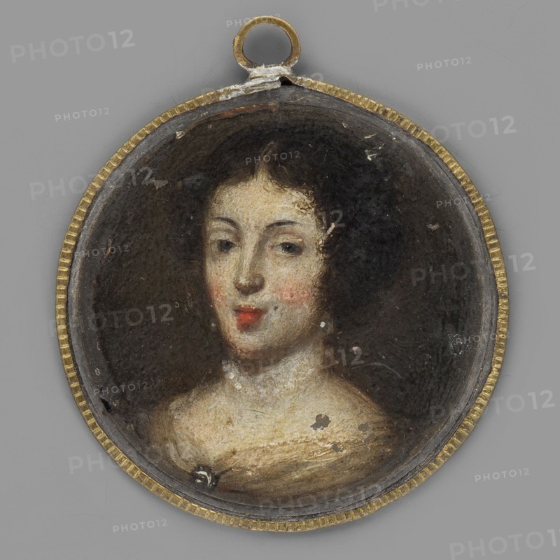 Queen Marie Casimire de la Grange d'Arquien Sobieska 1641-1716, unknown artist, en face female portrait, Polish miniature, 1680. Bust 3/4 left; brown hair in curls around the face; dangling earrings with elongated pearls; pearl necklace; yellow dress with wavy white fabric at the bodice fastened with a brooch. Background dark olive-brown. Height 4.4 cm. On the reverse of the thaler, an image of the Saxon elector John George 1648 and a Latin inscription on the rim. Binding: enclosed in a narrow strip of yellow metal with a serrated edge., A small round pendant with a thin golden rim and a loop at the top contains a painted portrait of a woman shown from the shoulders up; she has pale skin with rosy cheeks, dark curled hair, dark eyes, and red lips, and she appears against a dark background with visible tiny areas of paint loss and surface wear in the pendant's interior; surrounding colors include gold on the rim, black and dark brown in the background, pale beige and cream tones for the...