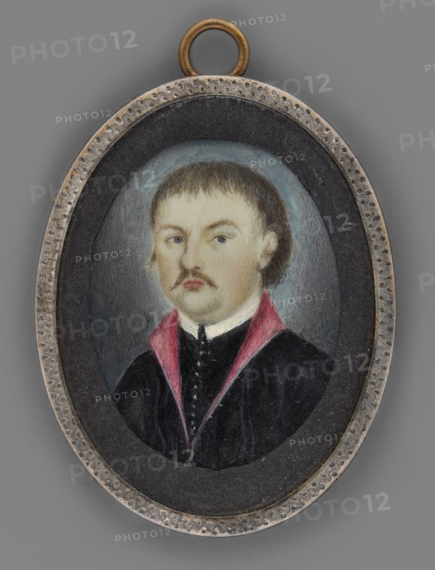 Teofil Wisniowski 1805/6–1847, participant in the November Uprising and Carbonari in Galicia; painter amateur. Three-quarter portrait of a man; miniature, height 4.9 cm, width 3.8 cm; dated circa 1840, Poland. Bust slightly turned to the left. Dark blond hair and mustache, gray eyes. Wears a white collar, black zupan with a row of silver buttons, and a black kontusz with magenta lapels. Background ash gray, lightened around the head. Frame: mismatched oval rim of zinc-plated silver; convex glass. On the reverse of the binding a label inscribed: Teofil Wisniowski / executed in Lviv on Execution Hill in 1846. Historical notes: emigrant, publicist, social activist; participant in the November Uprising 1830–1831 and organizer of the 1846 underground uprising in Galicia; in 1846 commander of a unit fighting Austrians near Narajów; captured by two Rusyn peasants, handed to the Austrians, arrested, sentenced to death and hanged in 1847 on a hill near Lviv known thereafter as Death Hill., An o...