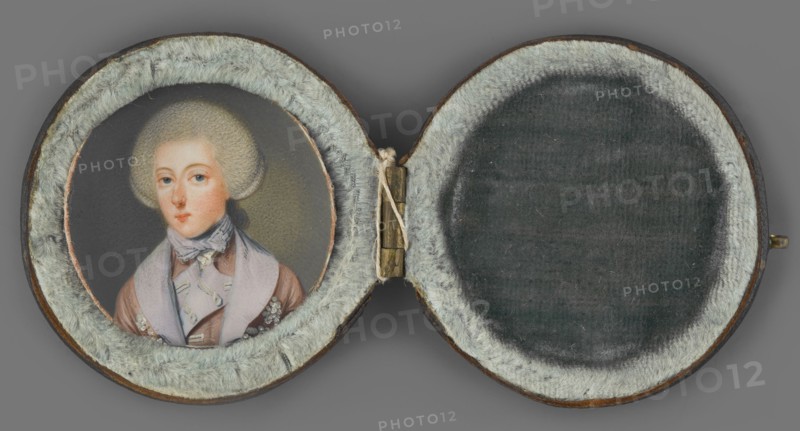 Portrait of a young man in a gray wig; artist unknown. Three-quarter male portrait, ca. 1770, miniature. Bust almost straight, head slightly turned left. Large spherical wig with a pigtail at the back. He wears a short tied lilac cravat and a gray-pink tailcoat with lilac-colored lapels embroidered with silver flower buds. Background gray-olive, lightened on the right near the head. Housed in a round black leather case lined with gray-green plush., A circular hinged case opened to reveal a painted portrait on the left and a padded empty space on the right, both surrounded by a soft furry lining. The portrait shows a person with a pale complexion and powdered hair, wearing a light-colored scarf tied at the neck and a coat with visible lapels and decorative details. The furry lining around the interior is light gray, and the empty padded area on the right is a darker gray with a slightly mottled texture. The case exterior rim appears brown, the hinge is metallic with a brass-like color, ...
