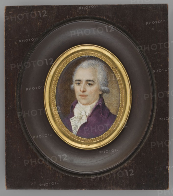 Portrait of a man in a purple tailcoat, bust three-quarters left. White wig; white cravat tied with a large bow, white vest with green stripes, purple tailcoat. Background brown, lighter greenish-sand around the head and left shoulder. Miniature, ca. 1900, France. Height 4.1 cm, width 3.7 cm. Frame: slightly recessed oval rim of gilded bronze in an oval recessed cut of a rectangular wooden frame, semi-polished bronze. Subjects: costumes, portraits en trois-quarts, men, male portraits, nobility, foreign miniatures., A painted portrait of an adult person with pale skin and powdered white hair set in an oval frame; the person wears a purple coat and a white ruffled garment at the neck, with a neutral facial expression and light-colored eyes. The portrait is surrounded by a decorative gold inner frame and a dark brown circular mat, all mounted on a rectangular dark wood panel that shows worn spots and scratches. The visible colors include white, purple, gold, dark brown, pale beige, and gr...