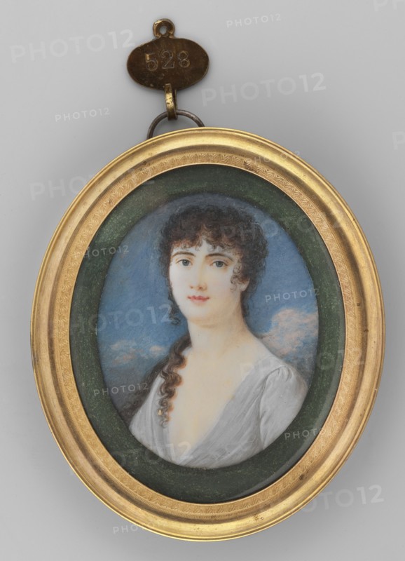 Portrait of a Young Girl, Restallino, Carlo 1776–1864, painter. Female portrait shoulder-length, young woman with braided hairstyle; three-quarter left bust. c. brown hair with a curling lock on the left shoulder, c. blue eyes, wearing a silvery-pink dress with a low neckline. Background of pink and c. grey clouds. Miniature, 1890; height 6.0 cm, width 4.8 cm. Binding: gilded bronze, convex rim, acanthus motif around the center. Repossession, An oval portrait in a gold frame hangs against a pale gray background; the frame surrounds a dark green inner ring and a painted oval scene showing a woman with pale skin and dark curly hair, some hair falling in a long curl over one shoulder; she wears a low-cut light gray or white dress and looks forward with a neutral expression; the painted background behind her is blue with pale cloud-like shapes; a small metal loop and an attached oval tag are visible above the frame in a darker metallic color.