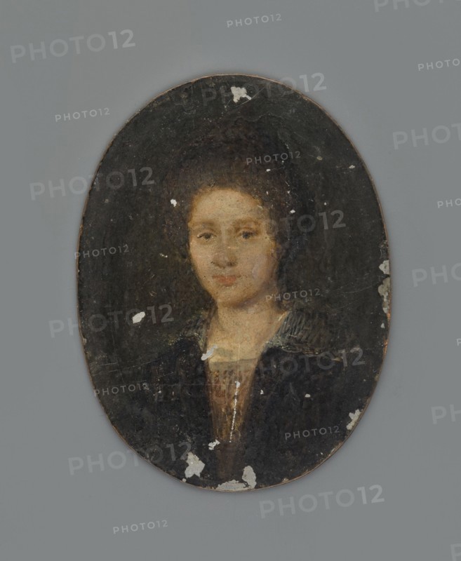 Portrait of a Woman after W. Mieris, after Willem van Mieris 1662–1747. Copy by unknown artist. Miniature height 5.2 cm, width 4.0 cm, dated ca. 1650–1690. En face female portrait, bust slightly turned to the left. Blonde hair combed up with a top knot; wearing a black dress, a cotton blouse of solid material at the front, and a transparent white collar on the shoulders. Dark olive-grey background. Inscription on the back of the board: With v Mieris., An oval portrait of a person set against a dark background, showing a head and upper torso with light skin and dark brown hair pulled back; the face has neutral expression and is rendered in warm beige and pink tones, with subtle shading; the clothing includes a dark outer garment in deep black and navy tones and a lighter inner garment in brown and tan shades, with a collar that has muted grayish stripes; the oval surface shows areas of surface wear and small patches where the paint is flaked, revealing lighter underlying tones; the surr...