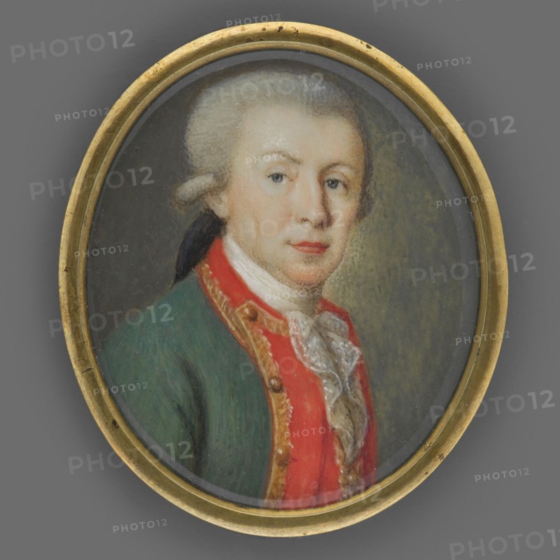 Landgrave Ludwig X of Hesse-Darmstadt 1753–1839, Grand Duke Ludwig I of Hesse, unknown artist, portrait bust, 3/4 right. Male portrait with grey wig with pigtail. Wearing green uniform tailcoat with red braided gold-edged collar, gold buttons, white cravat and white lace jabot. Background grey-olive, brighter on the right. Narrow brass rim binding. 1780, Germany. Miniature; height 4.0 cm, width 3.4 cm., An oval framed portrait of a person shown from the chest up wearing a green coat with a red front panel and gold trim, a white ruffled neckcloth, and a powdered wig tied at the back; the face has fair skin with light rosy cheeks and lips, pale blue eyes, and a neutral expression; the background is a muted gray-green and the frame is a worn gold color with small dark spots.