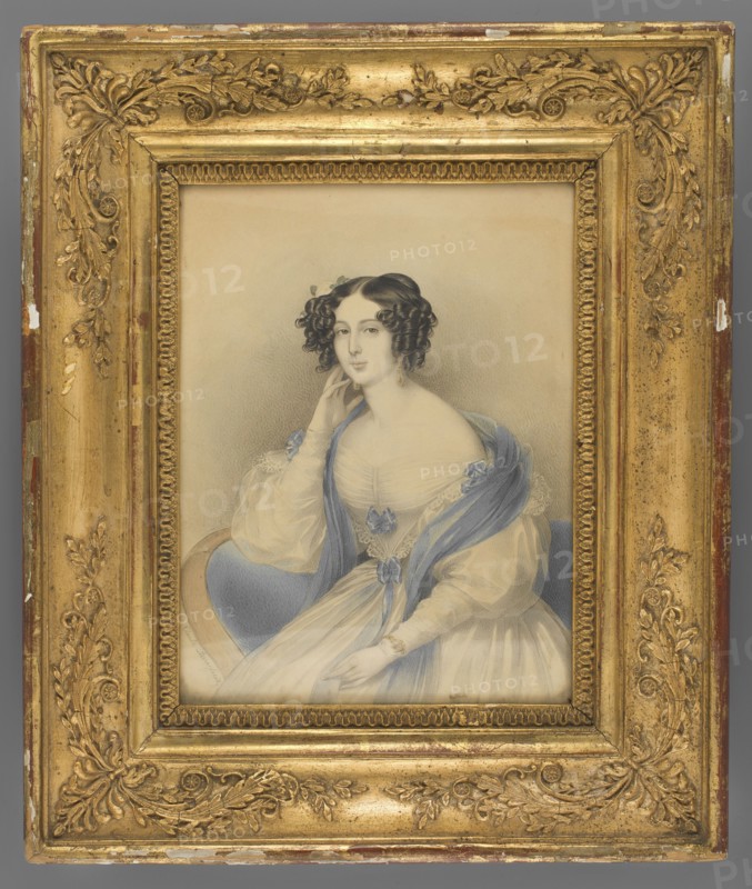 Count Paula de Bellegarde born Volkenstein-Trostburg, Pierre, Claude 1803-1854 painter, aristocracy, three-quarter portrait, flowers, woman, female portrait, dress, hairstyle, foreign miniature, 1840, miniature, height 21.8 cm, width 16.3 cm, A framed portrait of a seated woman shown from the waist up, wearing a pale dress with a sheer overlay and a blue shawl draped over her shoulders; she has dark curled hair styled with small adornments and is posed with one hand touching her face and the other resting on her lap, with a calm facial expression. The portrait is set against a neutral, softly shaded background. The ornate frame surrounding the picture is gold with decorative floral and scroll motifs and shows areas of wear with small spots of underlying colors. Visible colors include gold, blue, pale cream, beige, gray, brown, and touches of darker tones in the hair and shading.