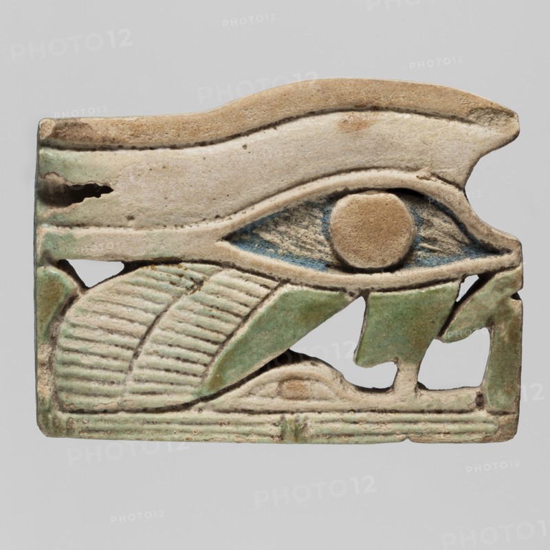 Amulet - udjat eye with falcon's leg and wing; udjat eyes; made ca. 747–656 BC, Third Intermediate Period, 25th Dynasty, Egypt; materials: amulet, height 3.5 cm, width 2.5 cm; associated with mummies, wings iconography, grave goods, Egyptian religion., A rectangular carved object depicting an eye motif with a rounded pupil, surrounded by a raised eyelid shape and an arched brow, all rendered in a weathered beige tone with areas of blue inside the eye and green accents on the lower elements; the lower portion shows a stylized leaf-like form with ridged texture in beige and green, and a segmented base with horizontal grooves in pale beige and green; the surface appears aged with small chips and worn edges, and the background around the object is a flat light gray.