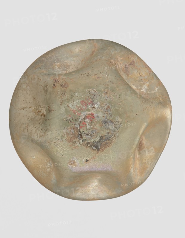 Flask, unknown eastern workshop, 3rd–4th century AD, vessel, height 11 cm, A rounded, irregularly shaped object with a lumpy, dented surface showing a mix of muted greens, pale beige, tan, and sandy browns, with areas of darker brown and rusty orange mottling. The surface has patches of rough, pitted texture and smoother, slightly glossy areas, with a central region that contains a mix of speckled discoloration in gray, brown, and dull red, and subtle iridescent sheen in places. The background is a uniform light gray.