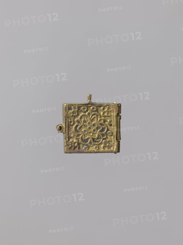 Diptych: Old Testament Holy Trinity and the Mother of God Znamienije, Old Believers' workshop; Mary mother of Jesus Christ; the Mother of God Znamienije iconographic; the Holy Trinity iconographic; angels; diptychs; the Mother of God with the Child iconographic; tree iconographic; mountain iconographic; inscriptions; Old Believers; maphorion iconographic; ; Golgotha iconographic. On the two wings of the diptych there are images of the Mother of God with Christ Emmanuel on her breast in a round medallion, and three angels sitting behind a trapeze. Identifying inscriptions are placed on both sides of the images. 18th–19th century, Russia; icon, diptych; height 3 cm, width 7.5 cm; 3 x 3.7 x 2., A small square metal object with a hinged edge and a tiny loop at the top, featuring an embossed floral-like rosette pattern in relief; the metal appears golden with areas of darker patina and small blue-green accents, all set against a plain light gray background.