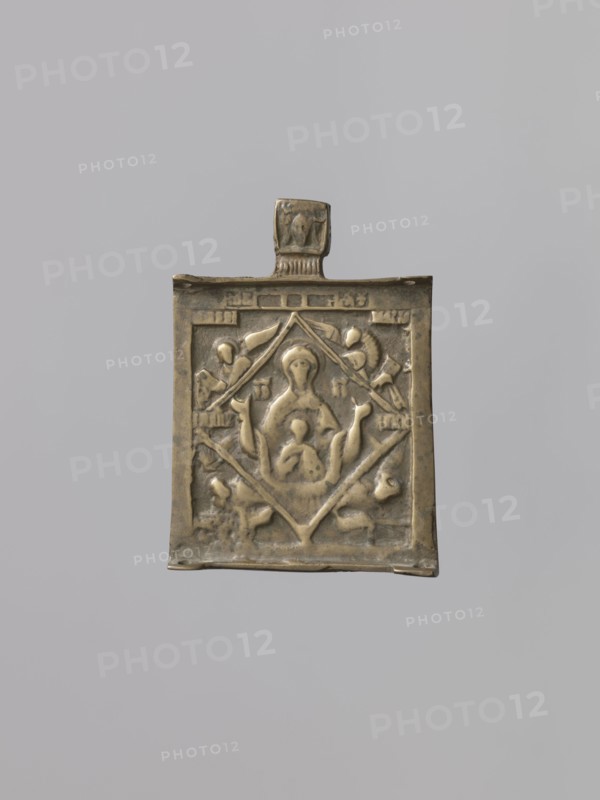 Middle wing of the triptych: Our Lady of the Signs and symbols of the four Evangelists, Russian workshop, Mary mother of Jesus Christ, Our Lady of the Signs iconography, Jesus Christ Bible, Mandylion iconography, evangelists, orantes, Our Lady and Child iconography, angels, bulls, inscriptions, lion iconography, eagle iconography. In the center of the icon is depicted – in bust form – Our Lady of the Signs with the image of Emmanuel blessing Christ on her breast. She is shown against a rhombus background; the icon's corners depict the symbols of the Evangelists. The face of the Savior not created by human hands is visible on the pendant. The relief of the cast is worn over the entire surface. 16th century, Veliky Novgorod probably, triptych middle wing, height 7.5 cm, width 5.5 cm, A small rectangular metal pendant with a tab at the top, shown against a neutral gray background. The pendant has a raised central panel with a stylized figure seated in the middle and a smaller figure in fr...