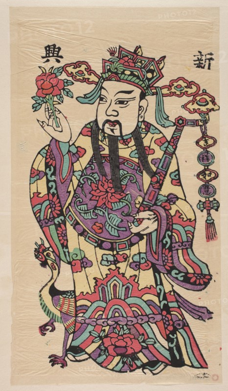Menshen Gate Guardian, gift; Chinese art, Chinese culture; nianhua New Year's picture showing a gate guardian depicted as a civil dignitary holding a ruyi auspicious scepter and a peony flower; early 20th century, Fengxiang; graphic print; height 51.0 cm, width 28.0 cm., A richly colored figure wearing an ornate headdress and flowing robes stands against a beige background; the headdress and robes show a mix of red, purple, teal, green, yellow, pink, black, and turquoise with intricate floral and cloud-like patterns, and the figure has a black mustache and long black beard and painted facial features; one hand holds a red and green flower-like object while the other holds a decorated staff with hanging circular ornaments in red, purple, green, and yellow; a stylized bird with multicolored feathers in teal, purple, red, yellow, and black appears near the figure’s lower robe, and additional decorative elements and scalloped patterns in similar colors surround the figure.
