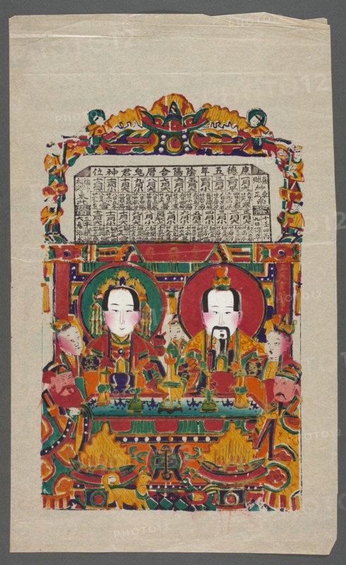 God of the Home Zaowang with his wife, nianhua New Year's picture, gods, Chinese art, Chinese culture, early 20th century, Yangliuqing, graphic print, height 39.2 cm, width 24.4 cm, A vertical image of a colorful painted print on pale beige paper showing a framed scene with two central seated figures with pale faces, dark hair, and ornamental headdresses, each within circular halos; they wear richly patterned robes in red, orange, green, and gold, and hold ceremonial objects on a decorated table in front of them. Surrounding the central pair are a group of attendants and smaller figures in similar colorful attire positioned on both sides and behind, all rendered with stylized facial features and flushed pale pink cheeks. The composition is enclosed by an ornate border and canopy featuring swirling floral and geometric motifs in bright colors including red, green, orange, yellow, purple, and teal, with gold-toned accents and dark outlines. The upper area above the seated figures contain...