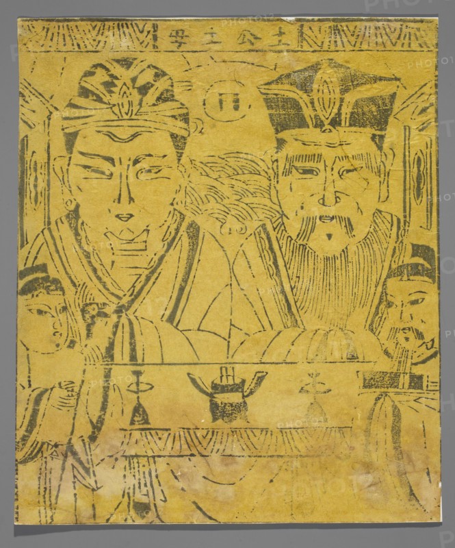 Prince and Mother of the Cultivated Land, Chinese, early 20th century, nianhua New Year's picture, graphic print, height 29.4 cm, width 25.0 cm., A yellow rectangular sheet with black ink line drawings depicting a group of human figures; two large central figures wearing ornate headpieces and robes sit or stand close together, each with stylized facial features and detailed hair or beard lines, flanked by smaller attendants on either side with simpler headwear; decorative patterns and curved lines fill the background and lower portion, including a horizontal band with ornamental motifs and a few object-like shapes on a table in front of the figures; the ink appears slightly faded in places and the paper shows small creases and worn edges, set against a neutral gray backdrop.
