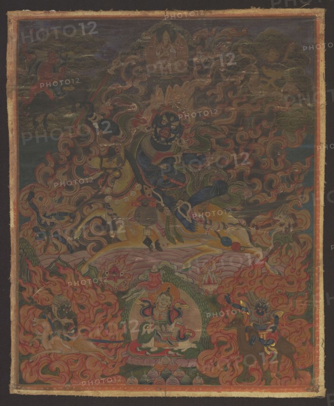 Palden Lhamo Sri Devi, Tibetan Buddhist art, Tibetan, painting thangka, depicting Goddess Palden Lhamo Tib. dpal ldan lha mo surrounded by acolytes: four demons, the guardian of heaven on a white lion holding an ichneumon in his left hand and an umbrella in his right — Kubera Skt. Vaishravana, Tib. rnam thos sras — and two zoocephalic dakinis: chu srin gdong ma Skt. Makaravaktra with the head of a Makara and seng ge'i gdong ma Skt. Simhavaktra with a lion head; iconography includes fire, flames, horses, skulls, demons, tantric Buddhist motifs, camels, fantastic creatures, wild boars, deer, lions, lotus throne, dharmapala. 19th century, Mongolia. Thangka scroll doublet; height 38 cm, width 31 cm., A richly detailed painted scene fills the image with a dominant central figure in dark blue surrounded by swirling flames and ornate patterns; the figure has multiple eyes and an elaborate headdress and sits astride a pale yellow horse. Around the central figure are several smaller figures, so...