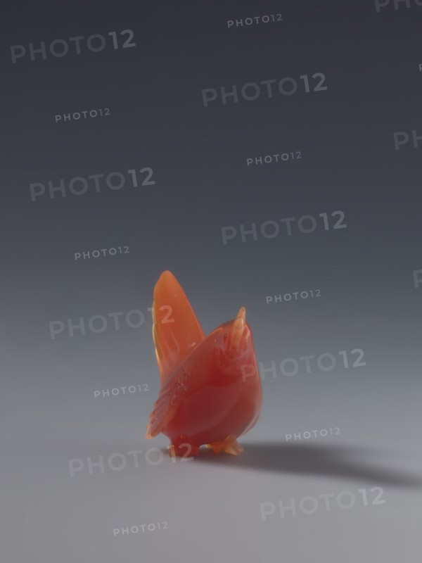 Hen; unknown sculptor; Chinese, Qing dynasty 1644–1911; 18th–19th century; sculpture figurine of a hen; material: Chinese art; dimensions: height 4.5 cm, width 5.0 cm, depth 2.3 cm., A small glossy bird figurine in shades of red and orange stands on a smooth surface, with a slightly darker red body and brighter orange on its wings and beak, casting a soft shadow; the background transitions from a dark gray at the top to a lighter gray near the surface.